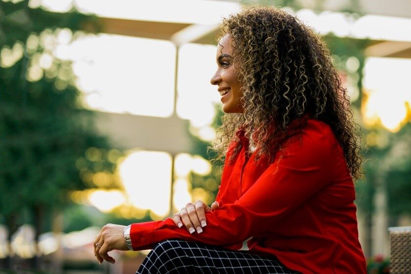 Candid portrait of Ereka Howard in a red jacket by a window